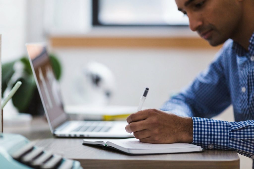 5 Ways To Boost Your Productivity While Being Busy 3 Man writing Luxafor