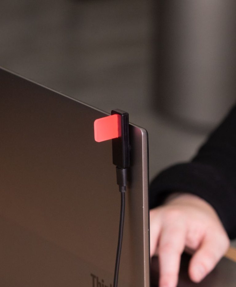 Luxafor Flag 2 glowing red meaning do not disturb attached to a laptop